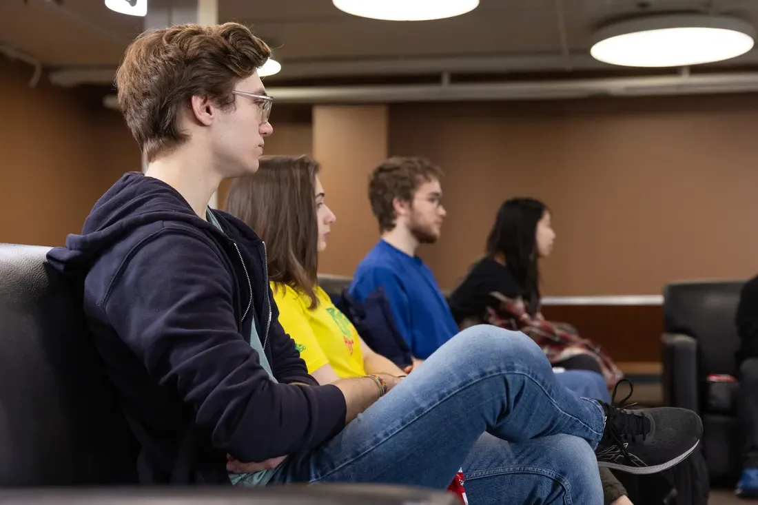 People sitting in chairs in a classroom.